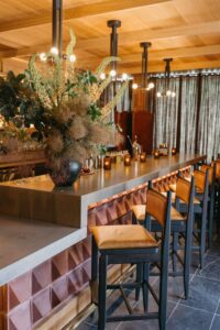 Image of the bar inside of the MOLLIE Aspen wedding venue featuring warm colors and textures surfaces