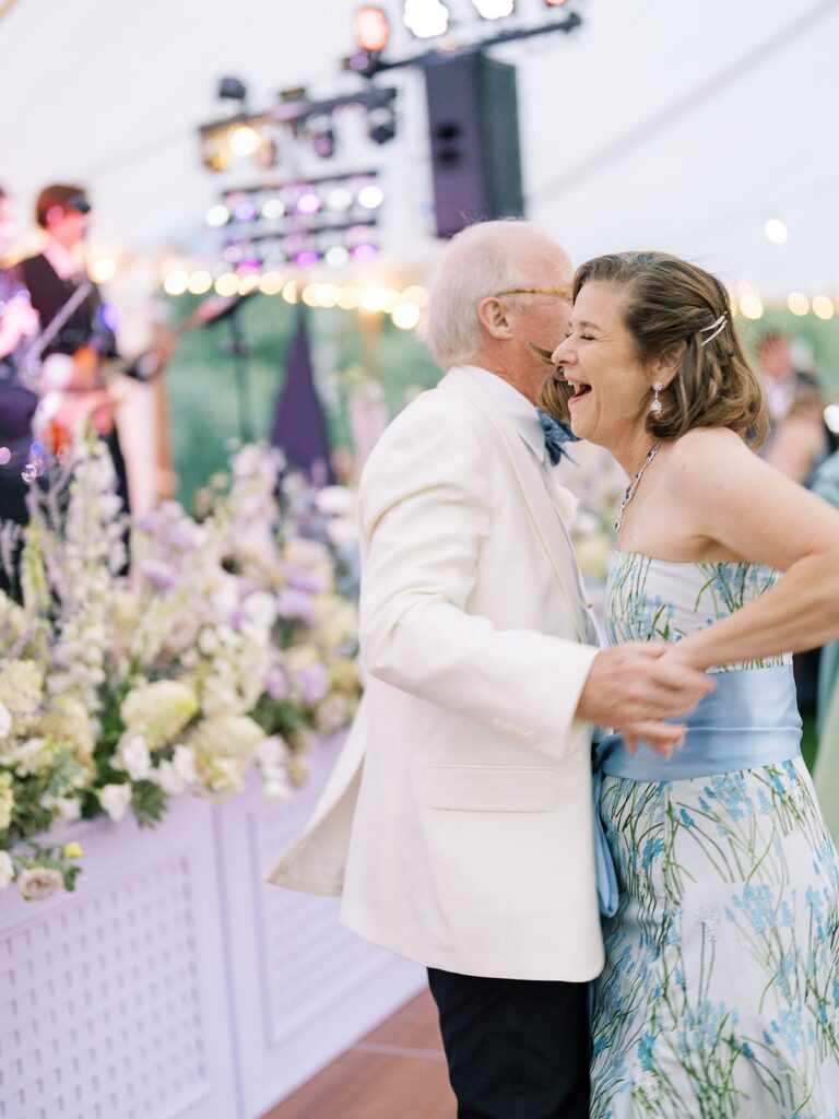 black tie wedding guest attire at a snowmass wedding reception near aspen, white dinner jacket with a bow tie and a floral blue evening gown