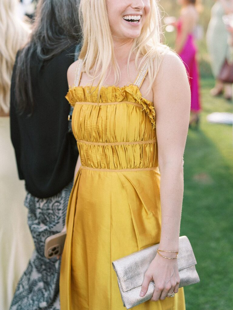 summer wedding guest style details at an aspen wedding, golden yellow dress with a silver clutch and gold jewelry